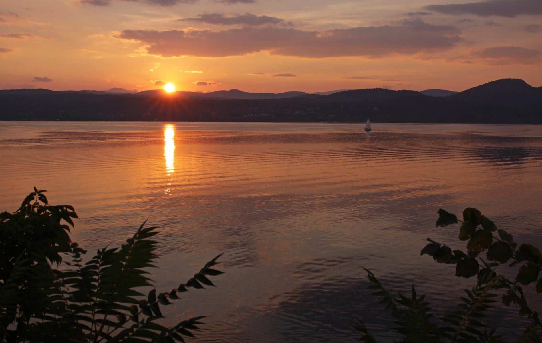 A sailboat sailing on Lake Champlain during a gorgeous sunset. Shot from the Vermont side near D.A.R. State Park.